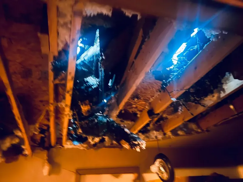 Damaged ceiling with holes showing daylight through roof, C&A Roofing & Construction
