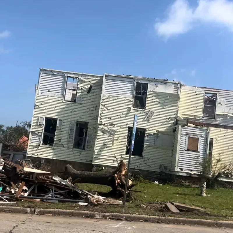 Severely damaged two-story house with siding torn off, C&A Roofing & Construction