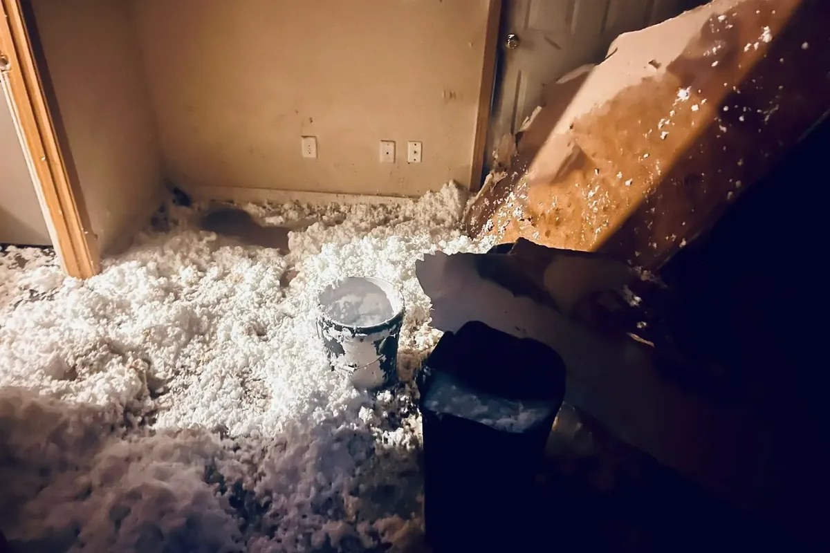Collapsed ceiling insulation debris in room, C&A Roofing & Construction